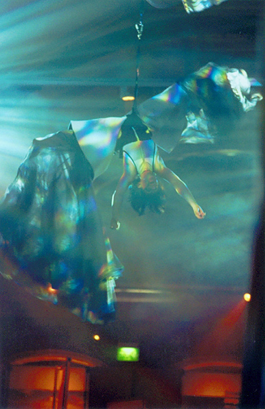 Performer suspended upside down adorned with hanging cloth
