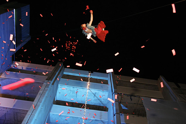 Performer suspended in air surrounded by confetti