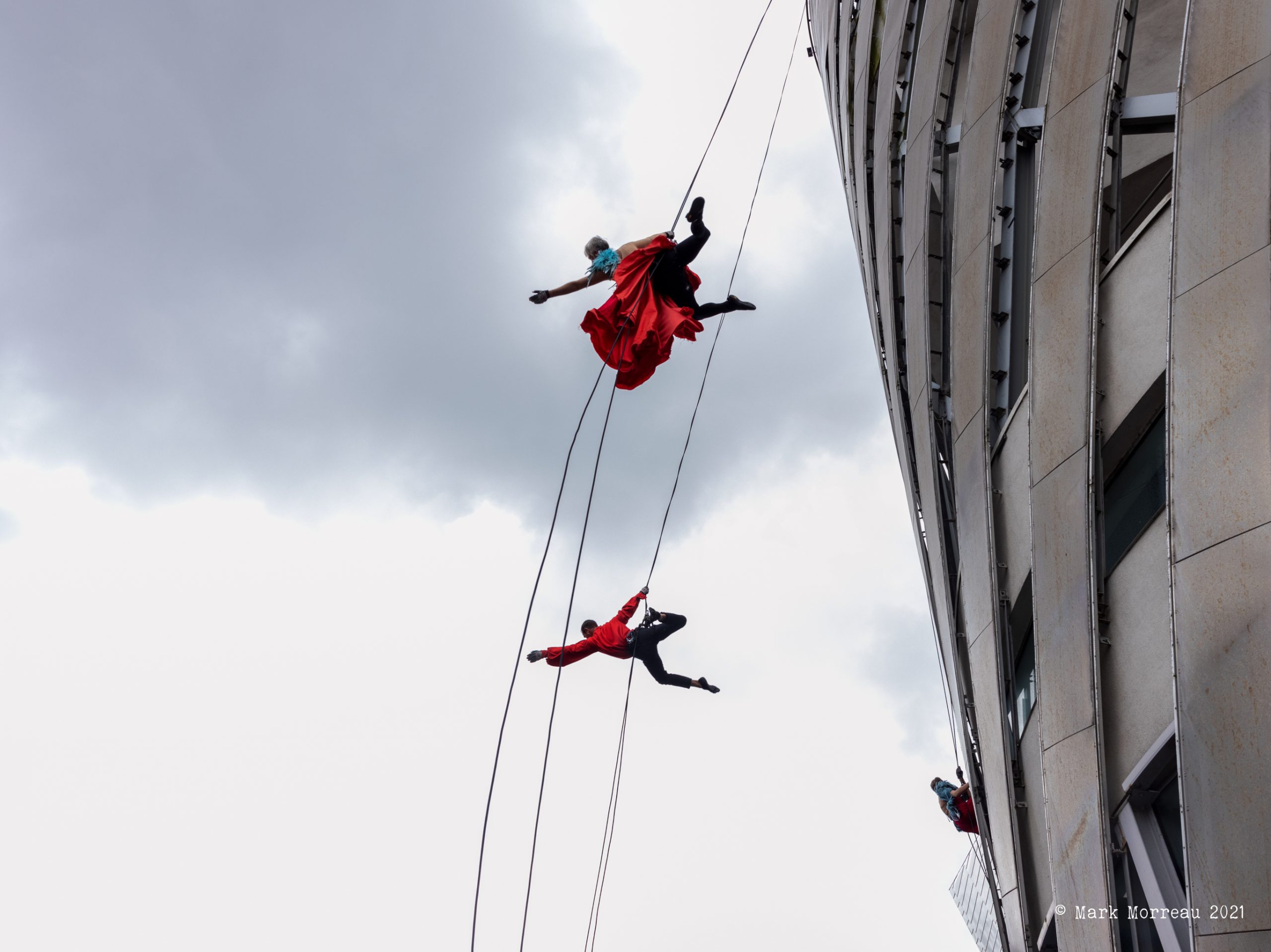 Two performers suspended above city road